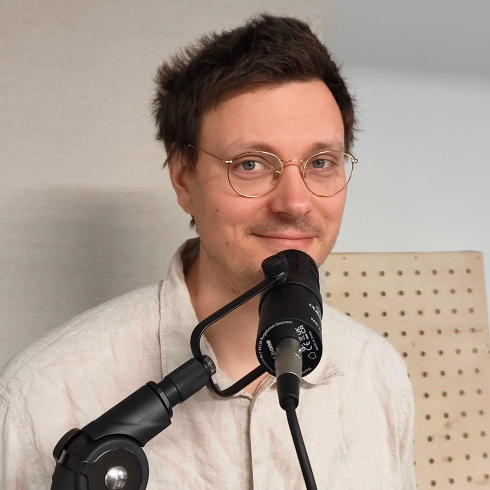 Foto von Nils vor einem Podcastmikrofon